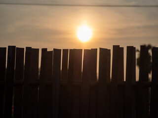 Light from the morning sun over a lattice bamboo fence