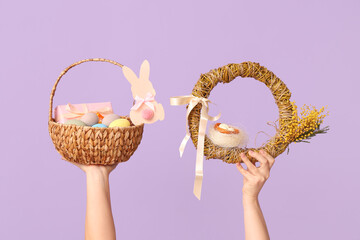 Female hands holding basket with Easter wreath on lilac background - Powered by Adobe