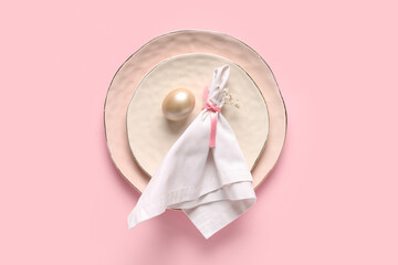 Beautiful table setting with Easter egg and gypsophila flowers on pink background
