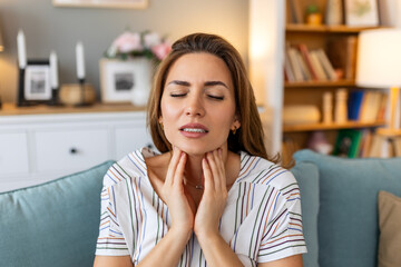 Close up of young woman rubbing her inflamed tonsils, tonsilitis problem, cropped. Woman with thyroid gland problem, touching her neck, girl has a sore throat - obrazy, fototapety, plakaty