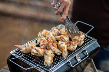 selective focus chicken drumsticks and chicken wings grilled on a holiday camping grill There is space for text. Chicken drumsticks and grilled chicken wings make you hungry, they look delicious.