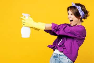 Side profile view excited young woman wears purple shirt rubber gloves do housework tidy up hold in...