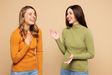 Side view young friend two women they wear orange green shirt casual clothes together talk each...