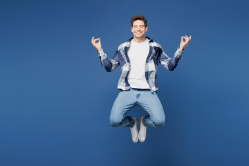 Full body young man he wears shirt white t-shirt casual clothes jump high hold hands in yoga om aum gesture relax meditate try to calm down isolated on plain blue cyan background. Lifestyle concept.