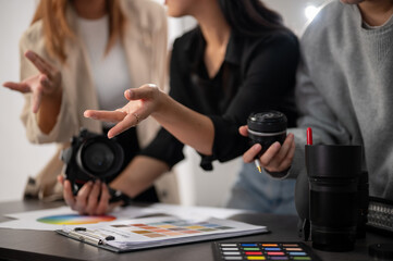 A cropped image of a professional, experienced female photographer working with her team in the studio.