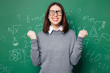Young smart teacher woman wear grey casual shirt glasses doing winner gesture celebrate clench...