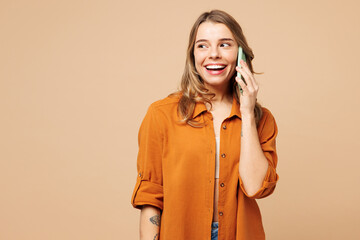 Young Caucasian woman she wear orange shirt casual clothes talk speak on mobile cell phone...