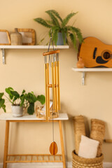 Golden wind chime hanging in light living room, closeup