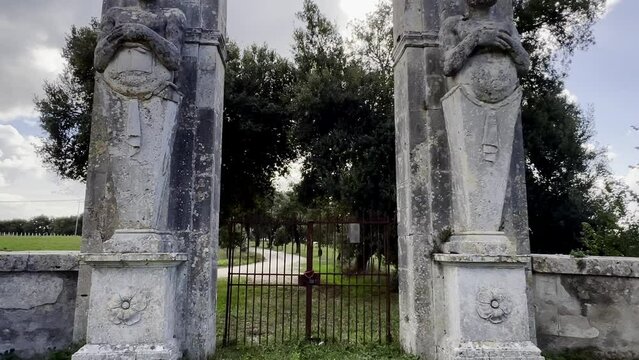 Mammalocchi busts travertine columns with allegorical figures standing at entrance to private villa in Umbria, Italy. Tilt up