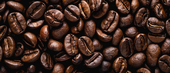 Fototapeta premium Roasted coffee beans on the table for background or design, top view. Coffee beans texture for background.