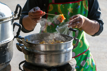 selective focus, even though the dim sum trader is taking food out of a steamer Dumplings in Thailand