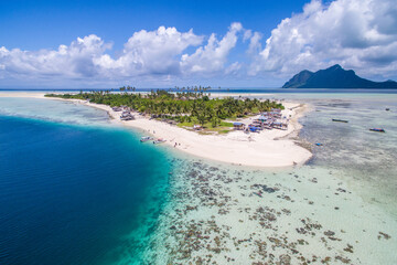 Aerial view of Maiga island panorama, beautiful blue lagoon and coral reef.