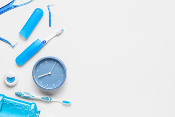 Alarm clock and set for oral hygiene on white background