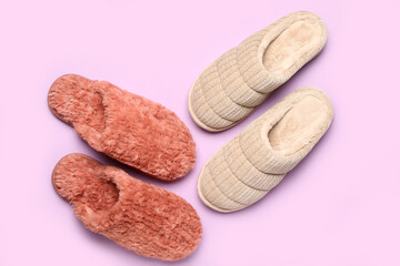 Two pairs of soft slippers on lilac background. Top view