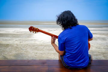 people playing guitar on the beach with dramatic tone