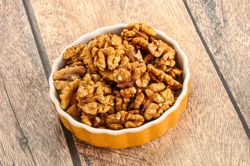 Cracked unshelled walnut in the bowl