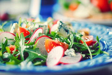 Healthy arugula salad with avocado, radish, bell pepper, tomato and Roquefort cheese