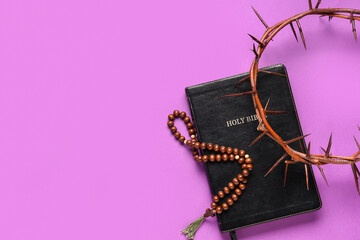 Crown of thorns and Bible, beads with cross on purple background. Good Friday concept