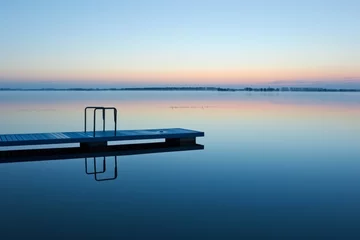 Poster empty diving board over calm water at sunrise © studioworkstock