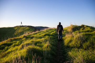 Man walking on the crater rim at Mt Eden summit. Auckland.