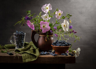 Modern still life with a bouquet of petunias and honeysuckle on a wooden table
