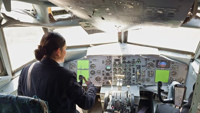 A woman is sitting in the cockpit of an airplane