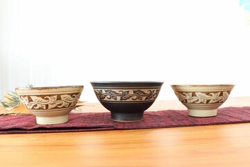 シックな色合いに複雑な模様が描かれたやちむんの茶碗