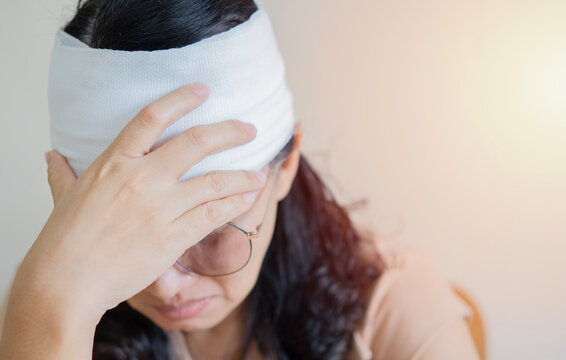 Shot of Asian woman with trauma of the head and wrapped bandages around her head.