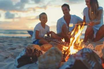 Fototapeten Happy family roasting marshmallows over campfire on beach at sunset  © PixelGallery