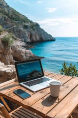 Laptop set up on a wooden table with a breathtaking view of the sea and cliffside.