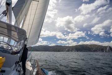 exploring the oceans and world while sailing a yacht with a sail on a beautiful day exploring the australian coastline of tasmania