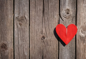 Bright red heart as a symbol of love and friendship on wooden background
