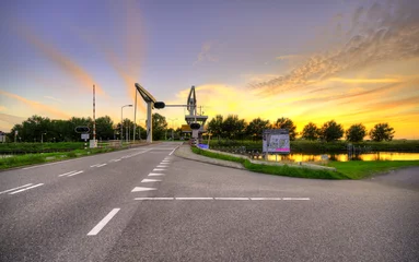 Fototapeten Dutch drawbridge named "Schoorldammerbrug" at sunset. © Alex de Haas