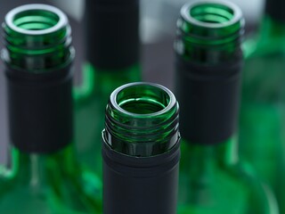 A close-up shot of the tops of open wine bottles