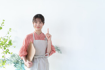 トレーを持ちエプロンをつけた女性