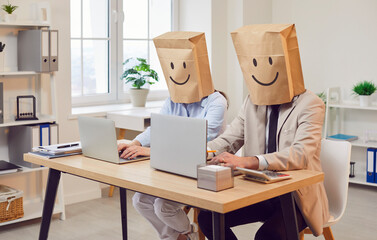 Two happy funny faceless company employees wearing paper bags on head with drawn smiling faces...