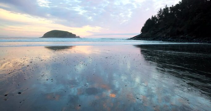 A beautiful beach with a small island in the distance. The sky is a mix of pink and blue, creating a serene and peaceful atmosphere