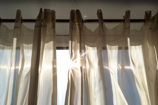 bright sunlight filtering through sheer curtains on a metal rod