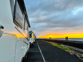 Many camper van motorhome vehicle parking on the road with amazing sunny sunrise sunset view....
