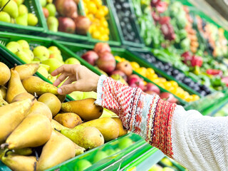 Closeup female hands taking fruits at the market, beautiful, pretty young woman in sweater picking...