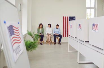 Polling station with a row of white voting booths decorated with American flag at vote center....