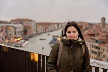 Young female tourist posing from the top of a building in Venice - obrazy, fototapety, plakaty