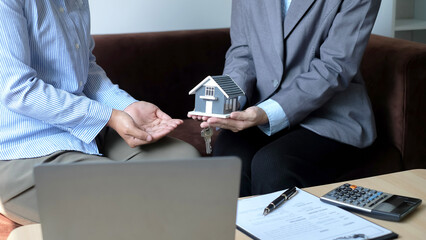 The real estate agent gives the house to a new owner's client after completing the signing of the...