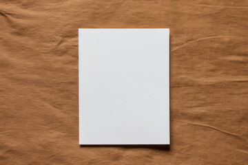 Blank white vertical paper on a crumpled brown paper background.
