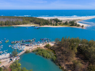 Aerial view of Loc An fishing village, Vung Tau city. A fishing port with tsunami protection concrete blocks. Cityscape and traditional boats in the sea.