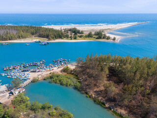 Fototapeta premium Aerial view of Loc An fishing village, Vung Tau city. A fishing port with tsunami protection concrete blocks. Cityscape and traditional boats in the sea.