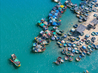 Fototapeta na wymiar Aerial view of Loc An fishing village, Vung Tau city. A fishing port with tsunami protection concrete blocks. Cityscape and traditional boats in the sea.