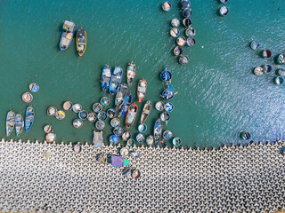 Aerial view of Loc An fishing village, Vung Tau city. A fishing port with tsunami protection concrete blocks. Cityscape and traditional boats in the sea.