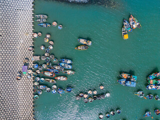 Aerial view of Loc An fishing village, Vung Tau city. A fishing port with tsunami protection concrete blocks. Cityscape and traditional boats in the sea.