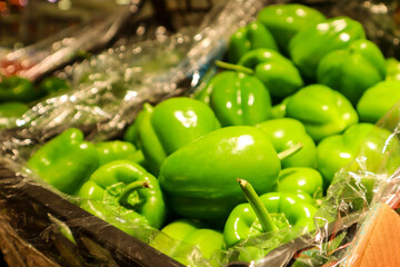 Green bell peppers, half and half composition. A few fresh green peppers on burlap on a wooden...